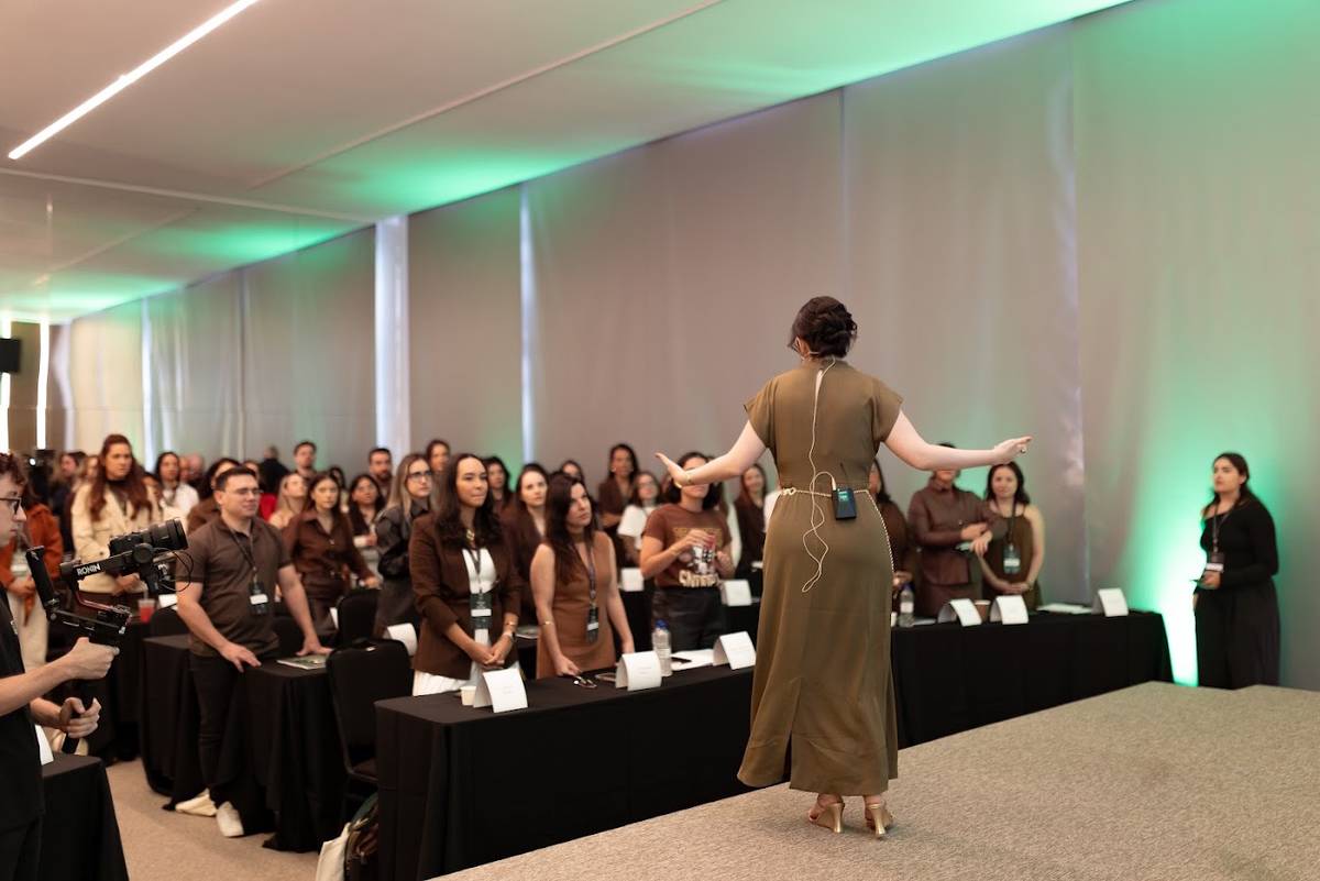 Sala cheia de participantes durante um encontro com a Marcela