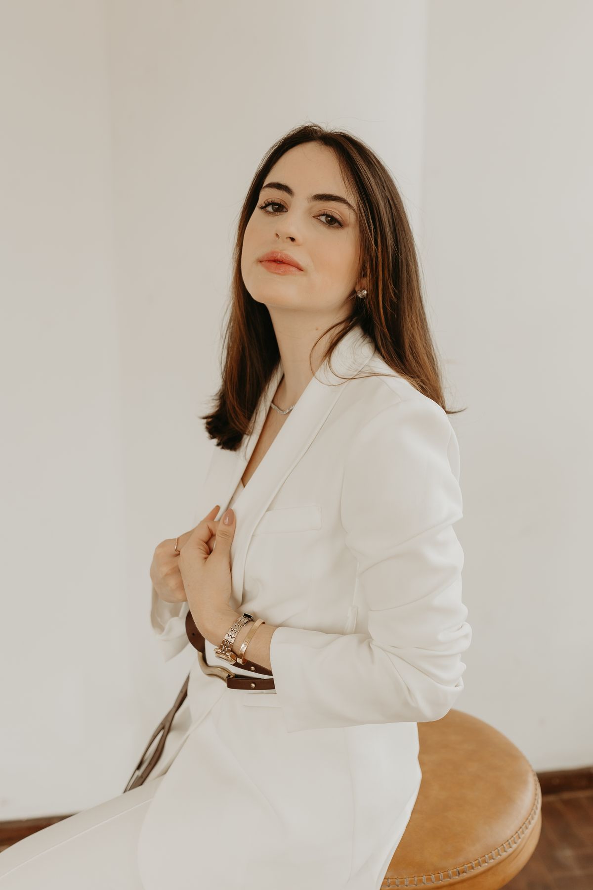 Marcela Lamastra de terno branco, olhando para a câmera